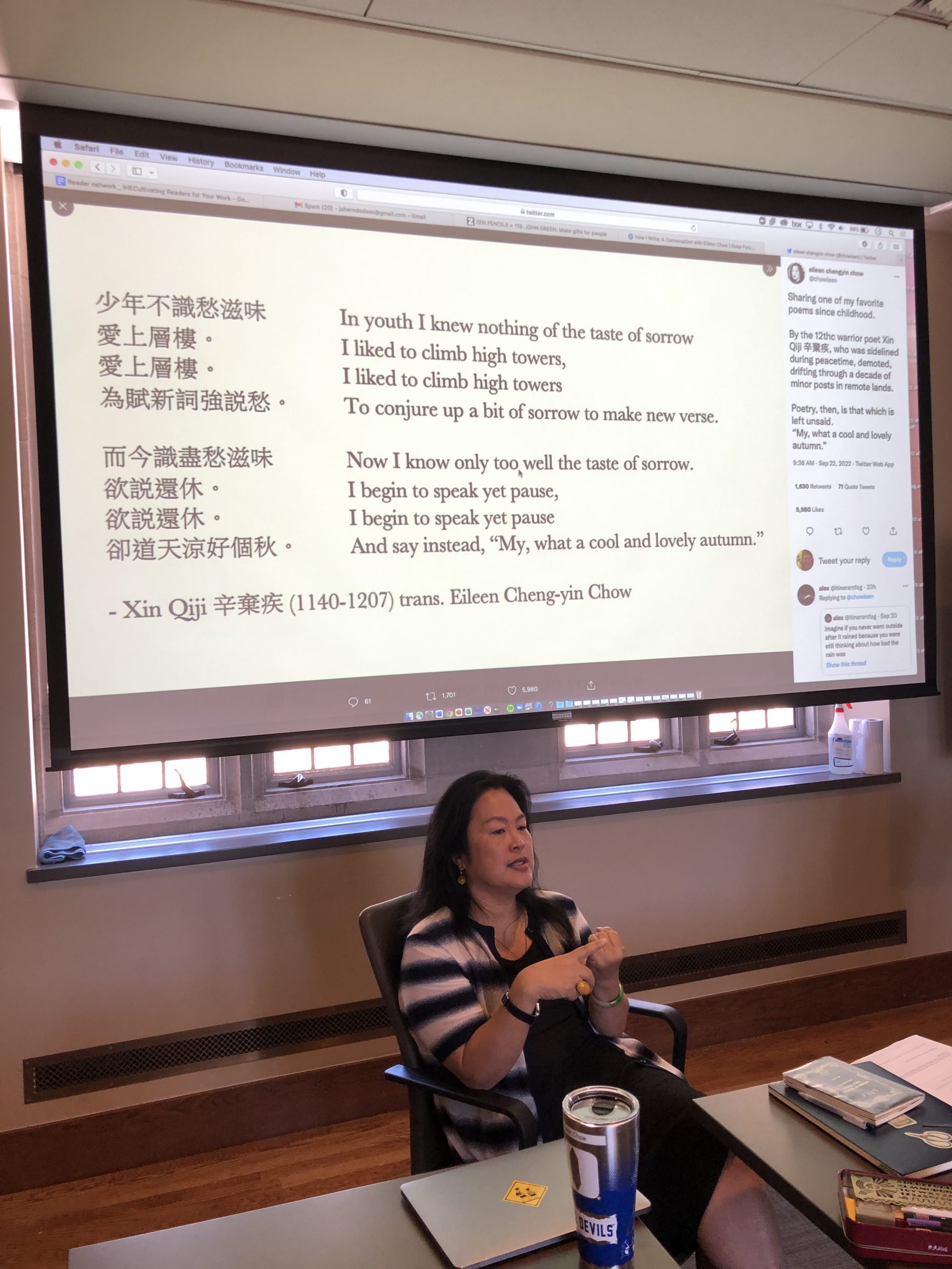 photo of a screen with a projected image of a tweet of a Chinese poem. 
